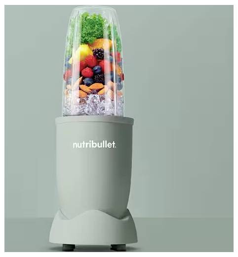 Čaša Nutribullet miksera napunjena šarenim voćem, orasima i ledom, spremna za miješanje.