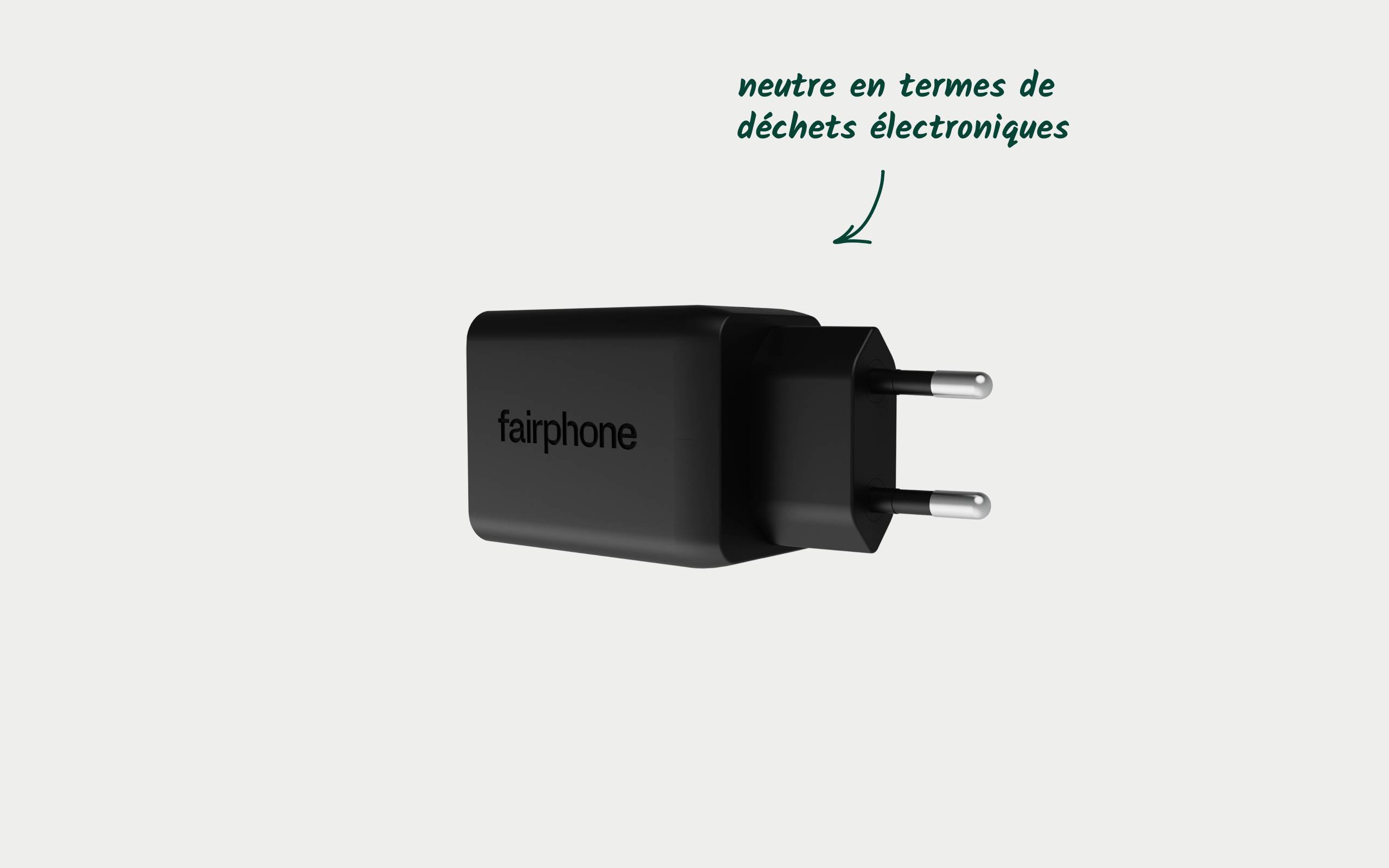 Crni punjač s natpisom 'fairphone'. Strelica upućuje na natpis 'neutralan u pogledu elektroničkog otpada'.