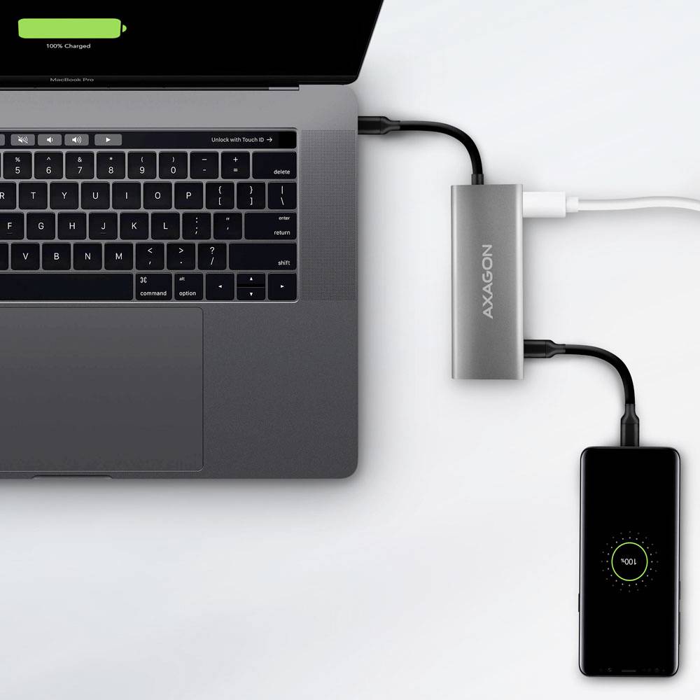 Prijenosno računalo i pametni telefon pune se putem USB concentratora. Na zaslonu prijenosnog računala piše '100% punjeno', dok telefon prikazuje ikonu punjenja.