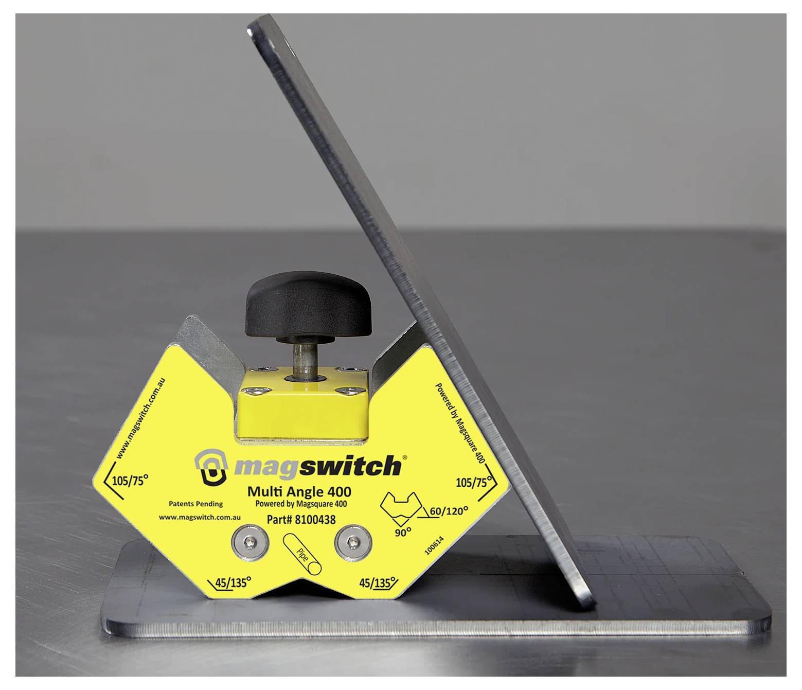 Žuti magnetski alat 'Magswitch Multi Angle 400' drži metalne komade pod kutom na metalnoj površini, demonstrirajući svoju sposobnost pozicioniranja.