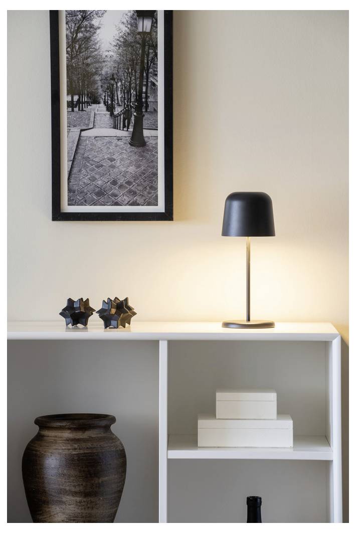 Ugodan unutarnji postav s crno-bijelom uokvirenom panoramom grada iznad police. Upaljena lampa i dekorativni predmeti naglašavaju minimalistički dizajn.