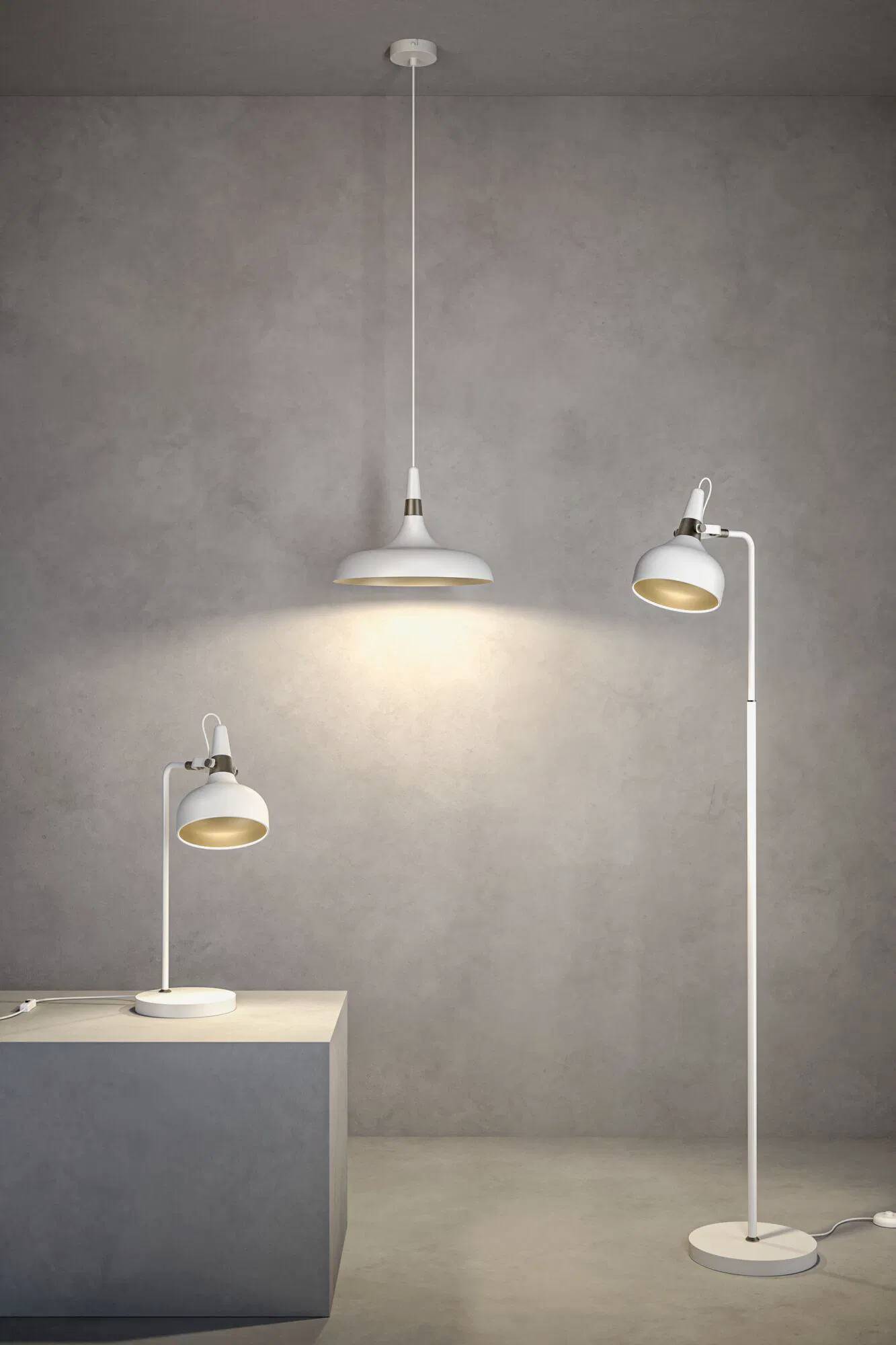 Tri moderne bijele lampe; jedna viseća i dvije podesive - stolna i podna, osvjetljavaju minimalistički sivi prostor.