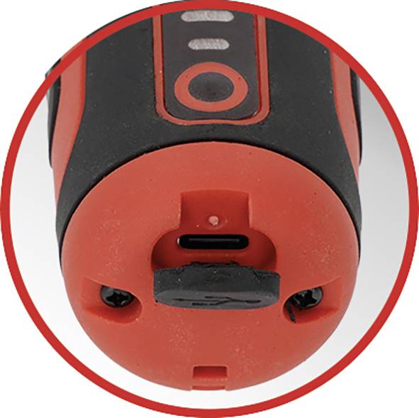 Krupni plan crveno-crne elektroničke naprave koja prikazuje USB priključak za punjenje na dnu, naglašen crvenim okvirom.