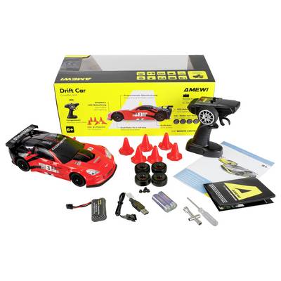 RC set uključuje crveni drift automobil, daljinski upravljač, dodatne gume, čunjeve, punjač, baterije i upute, prikazane u pakiranju.