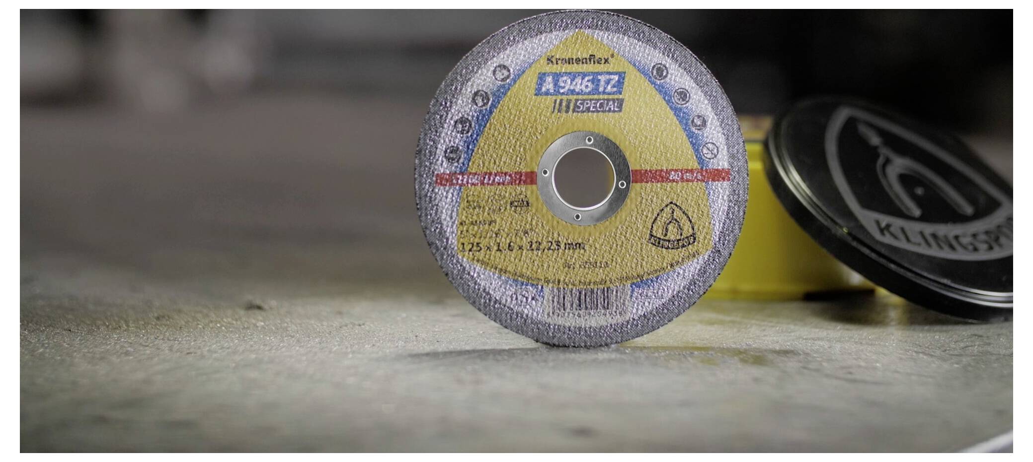 Bliska snimka reznog diska Kineticflex A 946 TZ s vidljivim detaljima oznake, koji leži na betonskoj površini, uz drugi disk koji je nejasno u pozadini.