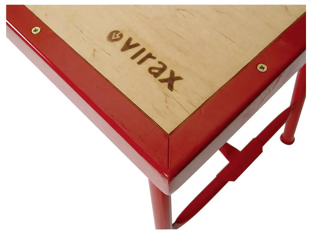 Blizak prikaz crveno okvira drvene površine stola sa ispisanom riječi 'virax' na njoj i vidljivi dio metalne noge za oslonac.