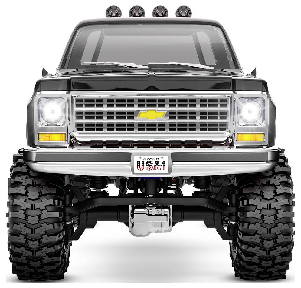 Čvrsti crni Chevrolet kamion s velikim off-road gumama, istaknute rešetke i svjetla na krovu. Registracijska tablica glasi 'USA1'.