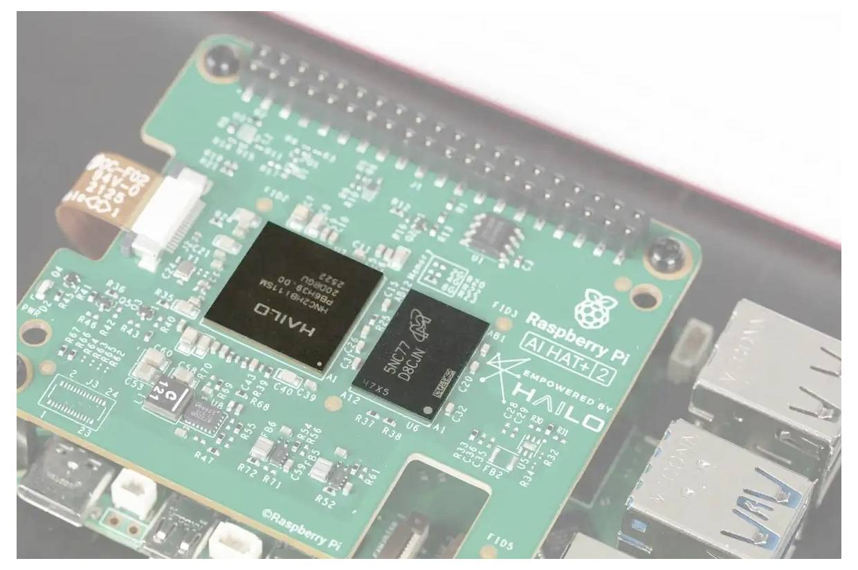 Detaljni pogled na modul Raspberry Pi AI Hat s zelenom pločom s čipovima označenim 'HAILO' i 'AI HAT 2'.