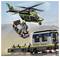 Helikopter igračka lebdi iznad vlaka, nosećI malo vozilo. Vlak je na tračnici. Scena je postavljena pred plavim nebom.