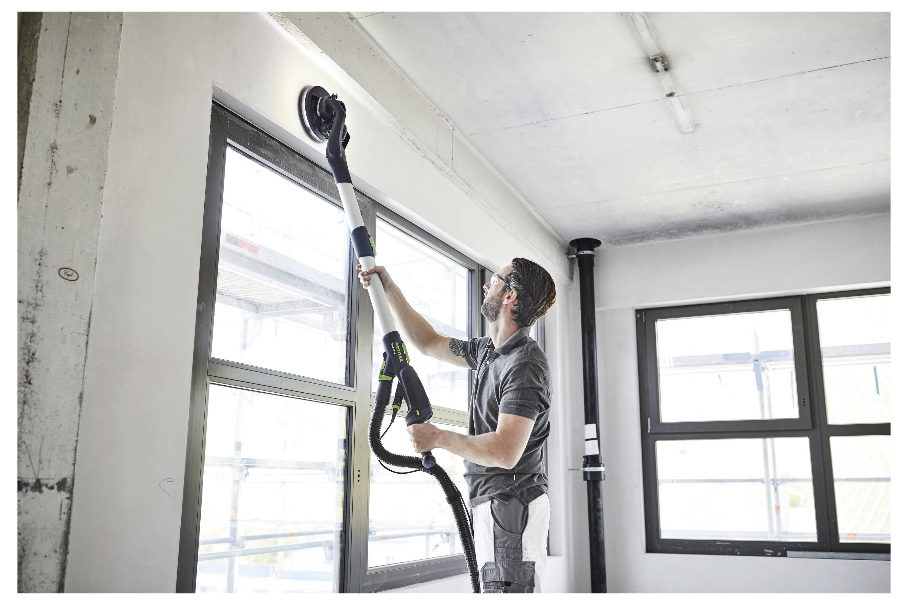 Ruka organizira male dijelove opreme u podijeljenom kutiji za alate na drvenom stolu, što ukazuje na učinkovito skladištenje i pristupačnost.