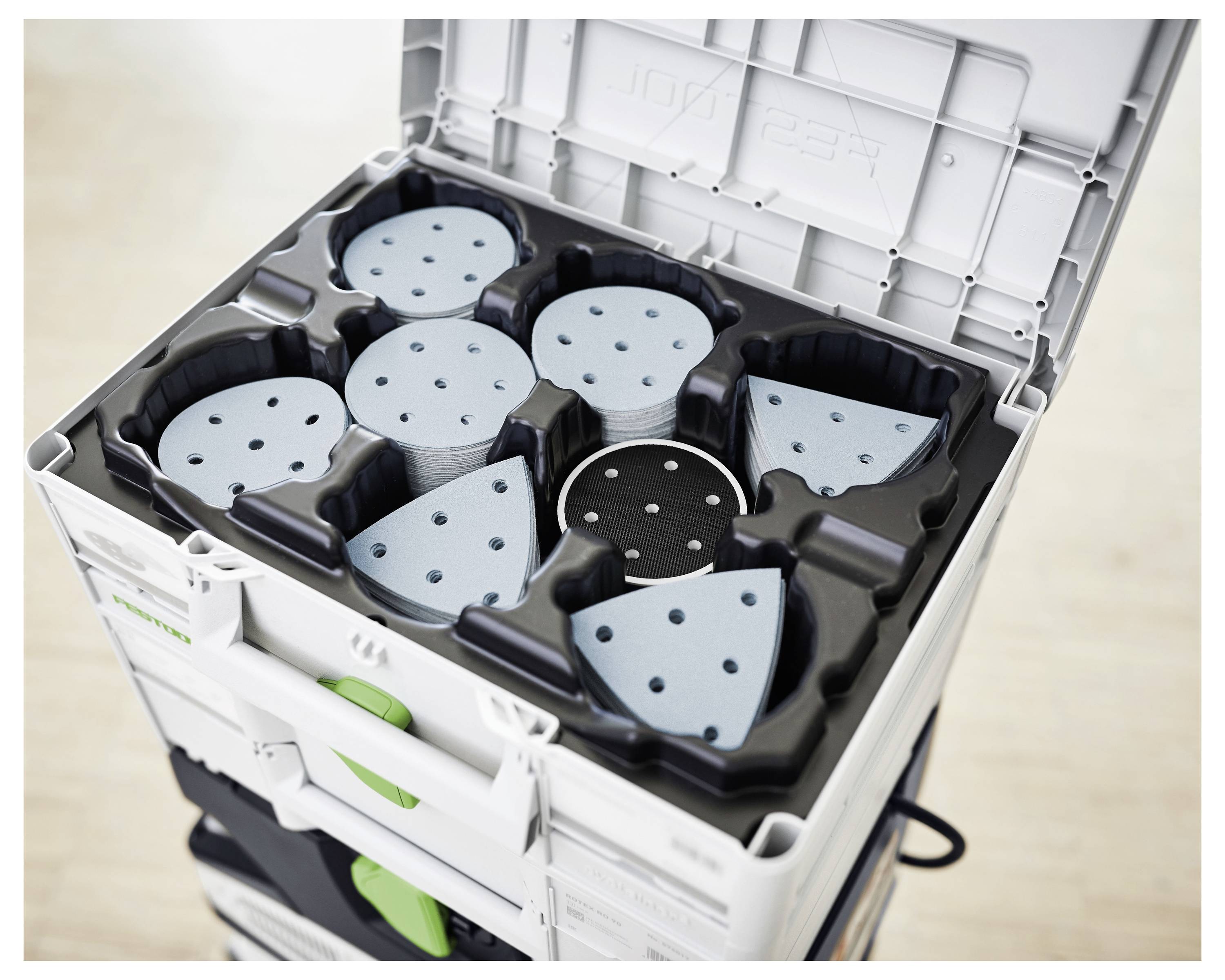 Otvorena kutija za skladištenje sadrži hrpice plavих i crnih kružnih diskova brusnog papira različitih zrnatosti, svaka organizirana u oblikovane pretince.