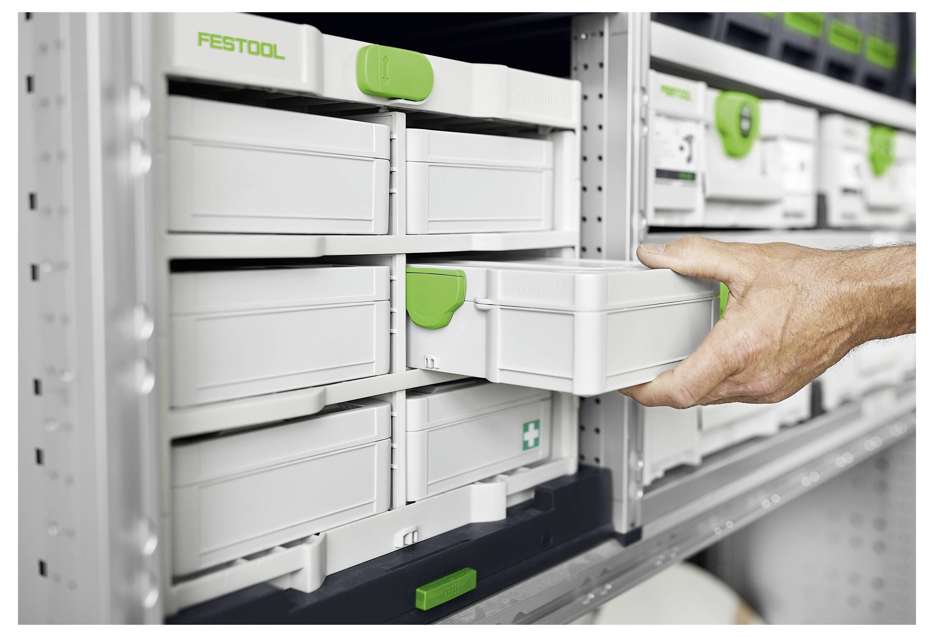 Ruka vuče ladicu iz sustava polica koja sadrži označene kutije za pohranu, pokazujući organiziranu pohranu alata ili opreme.