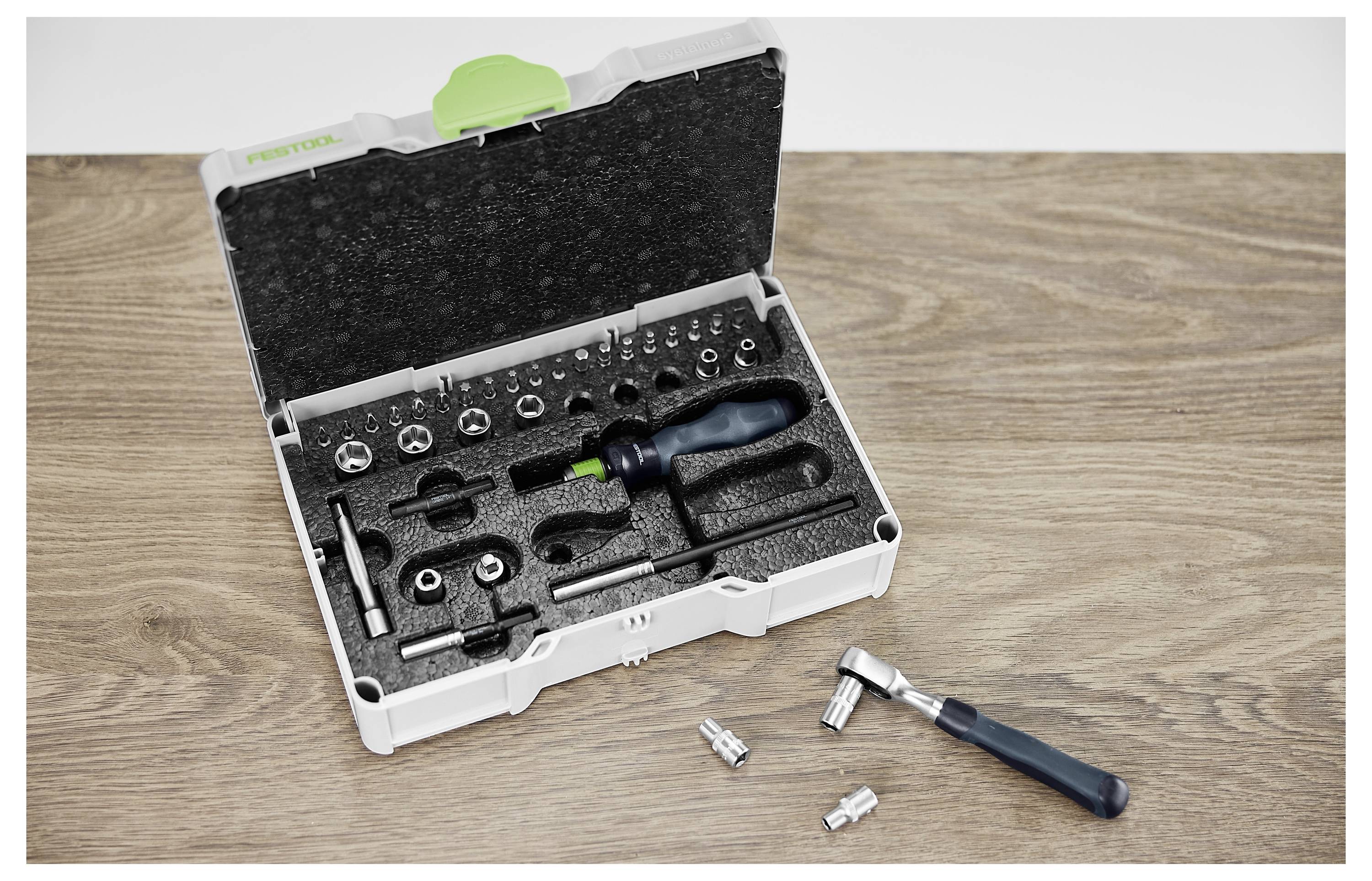 Osoba koristi električni alat za rezanje drvene daske, s fleksibilnom cijevi pričvršćenom na alat. Unutarnje okruženje radionice.