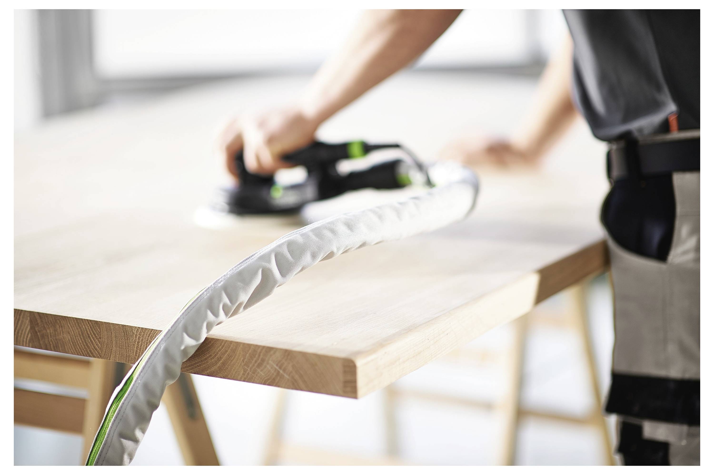 Osoba s rukavicama montira kružnu pilu na drvenom stolu, s alatima i komponentama u blizini, naglašavajući sigurnost i preciznost.