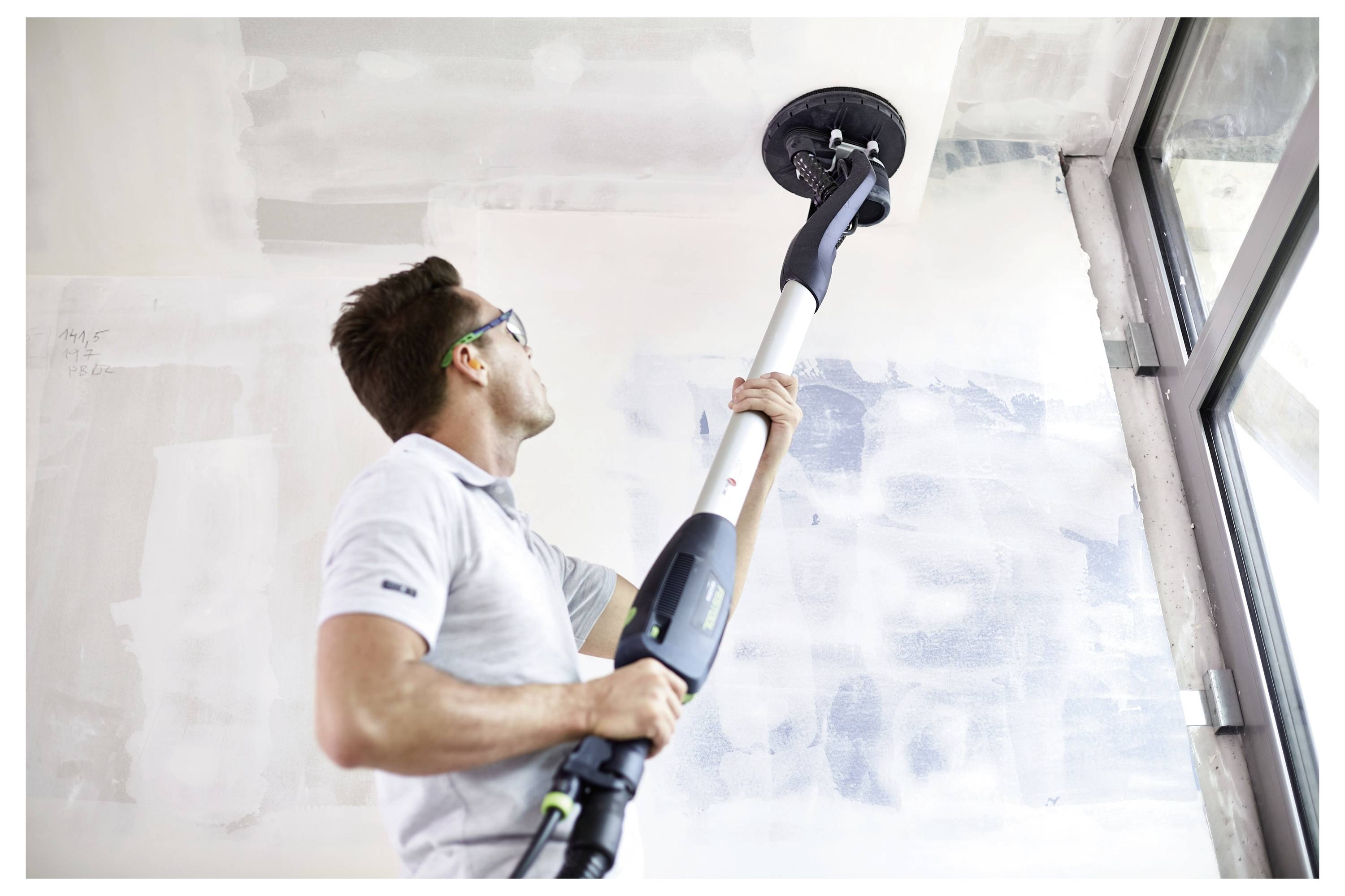 'Osoba podešava kružnu pilu za uglove u svijetloj sobi s drvenim podovima. Festool kutija s alatima nalazi se u prvom planu.'