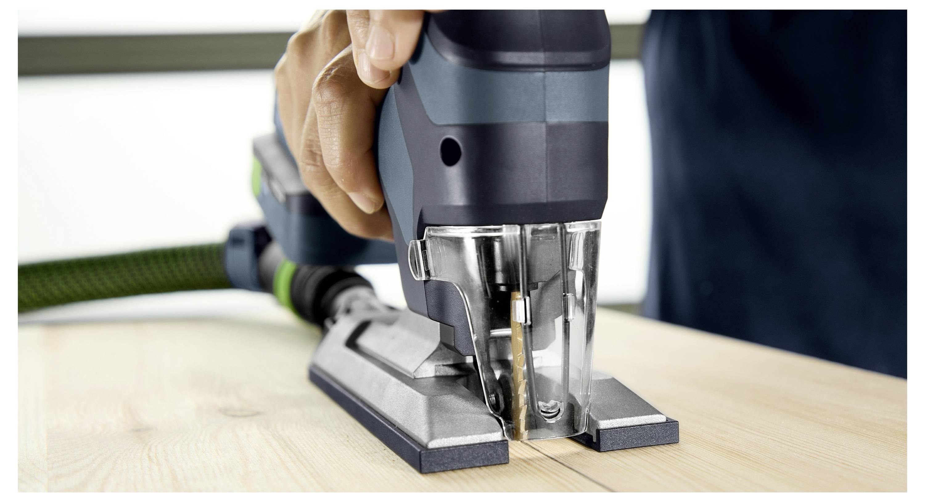 Osoba koristi ubodnu pilu za rezanje ravne linije na drvnoj ploči, fokusirajući se na preciznost reza.