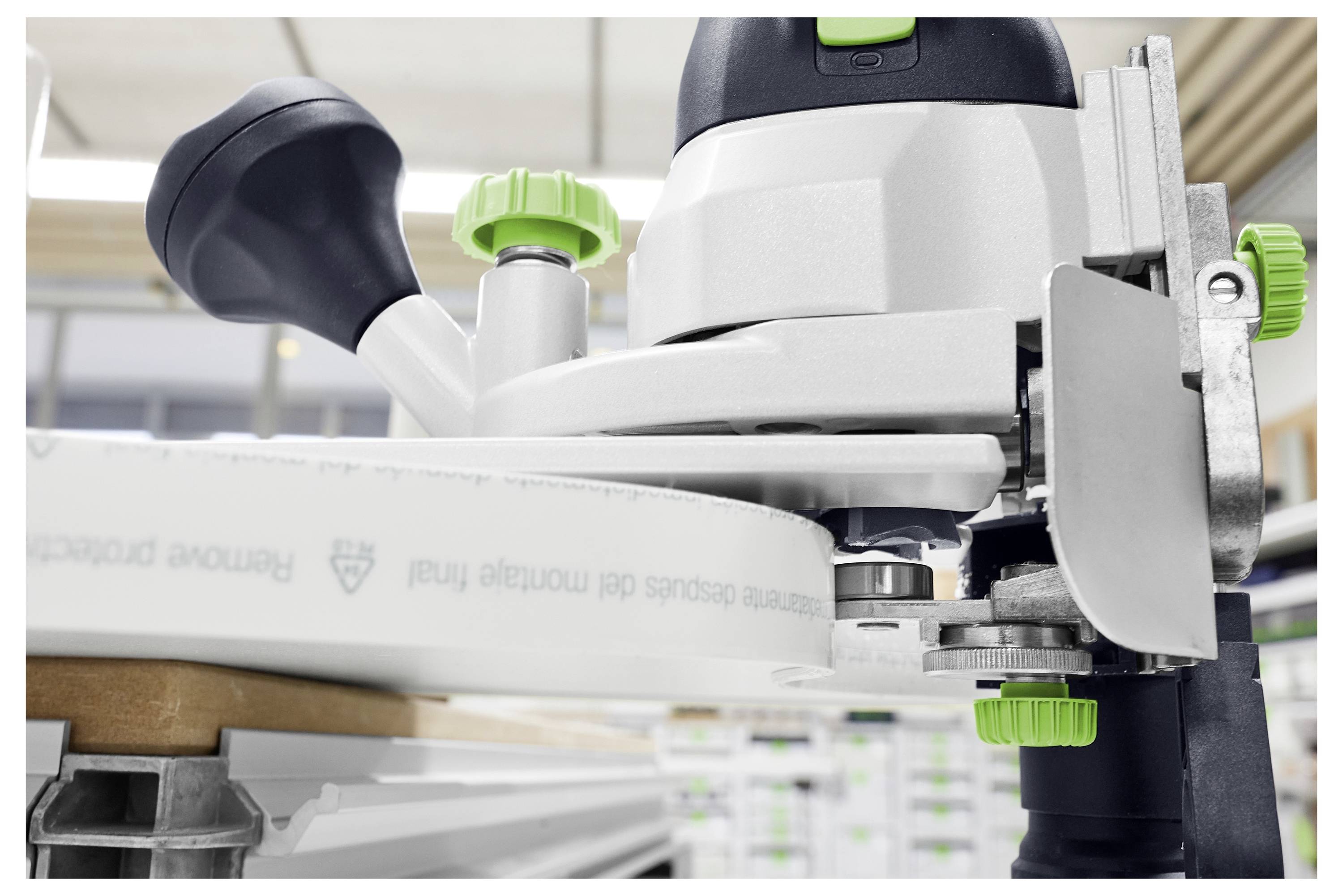 Snimak od blizu strugarskog usmjerivača sa zelenim dugmetima, fokusirajući se na njegov mehanizam preciznosti, u radionicskom okruženju.