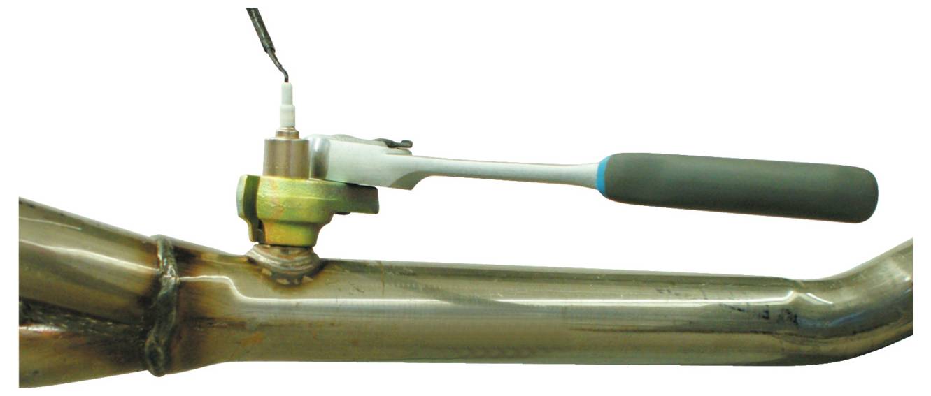 握柄接头连接到金属管上的传感器，可能用于在机械环境中拧紧或松开传感器。<br><br>Wait, let me provide the correct Croatian translation:<br><br>Rukovati s utičnicom povezan je sa senzorom na metalnoj cijevi, vjerojatno za zatezanje ili otpuštanje senzora u mehaničkom okruženju.