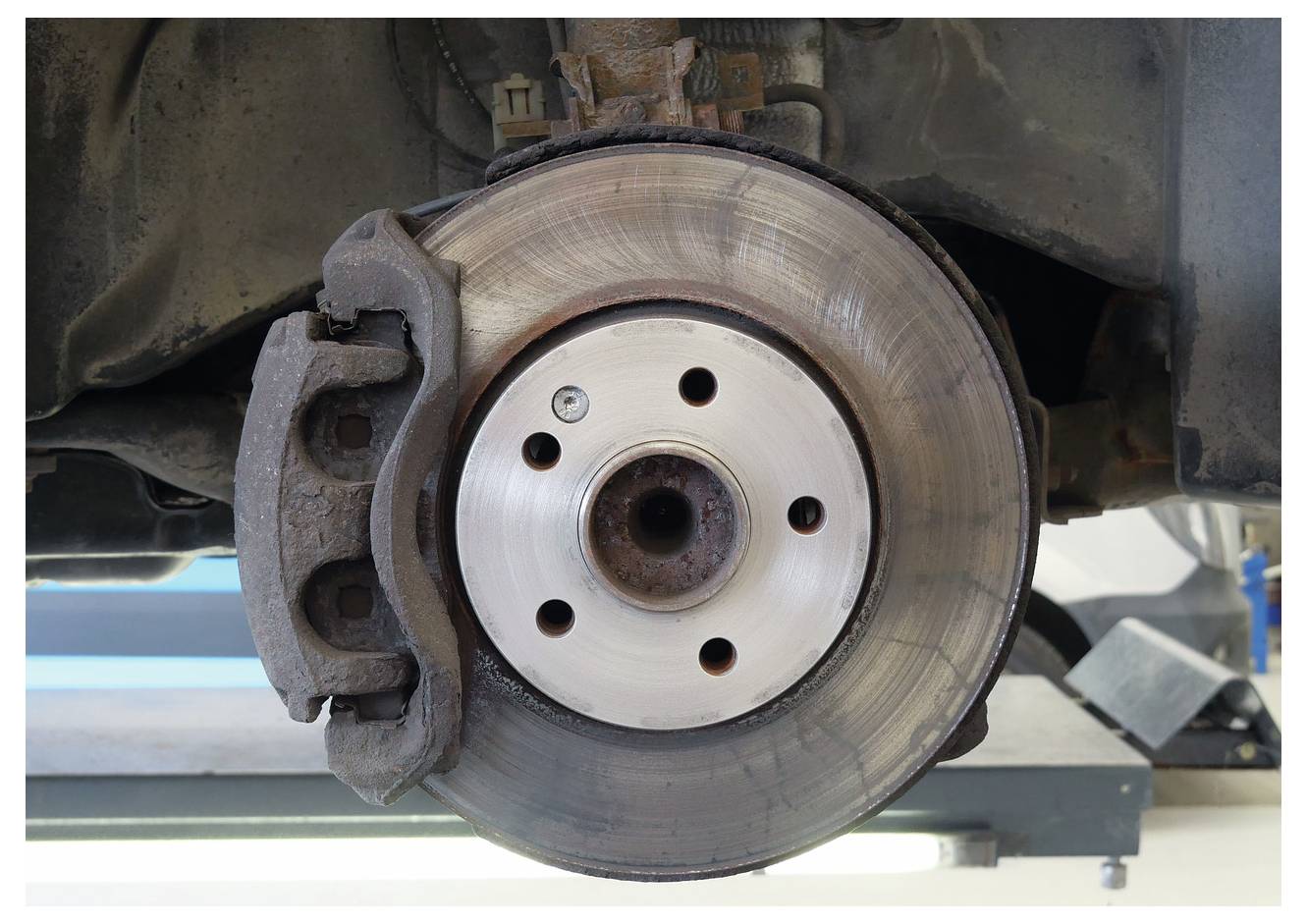 Disk kočnice automobila i kočiona čeljust prikazani su u detaljnom bliskom prikazu koji otkriva detalje površine diska i položaj čeljusti za održavanje.