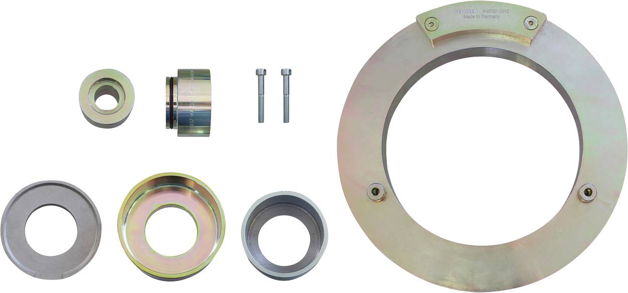 Skup metalnih automotivnih alata koji uključuje veliku kružnu ploču, manje prstene i dva vijka, korišten za potrebe popravke vozila.