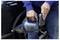 Osoba u plavoj majici koristi ručni usisavač za čišćenje automobila s tamnom vanjskom površinom.
