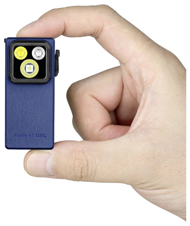 Ruka koja drži malu, plavu baterijsku lampu između palca i kažiprsta, prikazujući tri LED-a na prednjoj strani i natpis 'Made of MAL' graviran na njoj.