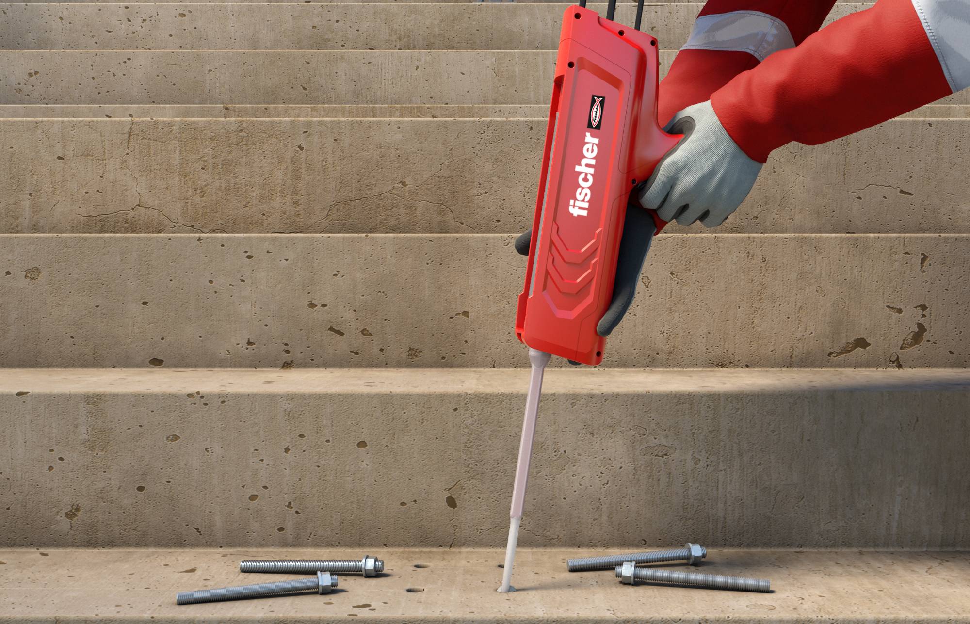 Rukavicama obučene ruke koriste crveni Fischer instalacijski alat kako bi zabili spojnu komadu u betonsku stepenicu, s sidrima i vijcima položenim u blizini.
