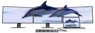 Tri monitora i prikaz laptopa prikazuju delfine kako skačу u oceanu, što sugerirajuće reprodukciju videa na više zaslona ili proširenu konfiguraciju zaslobnog.