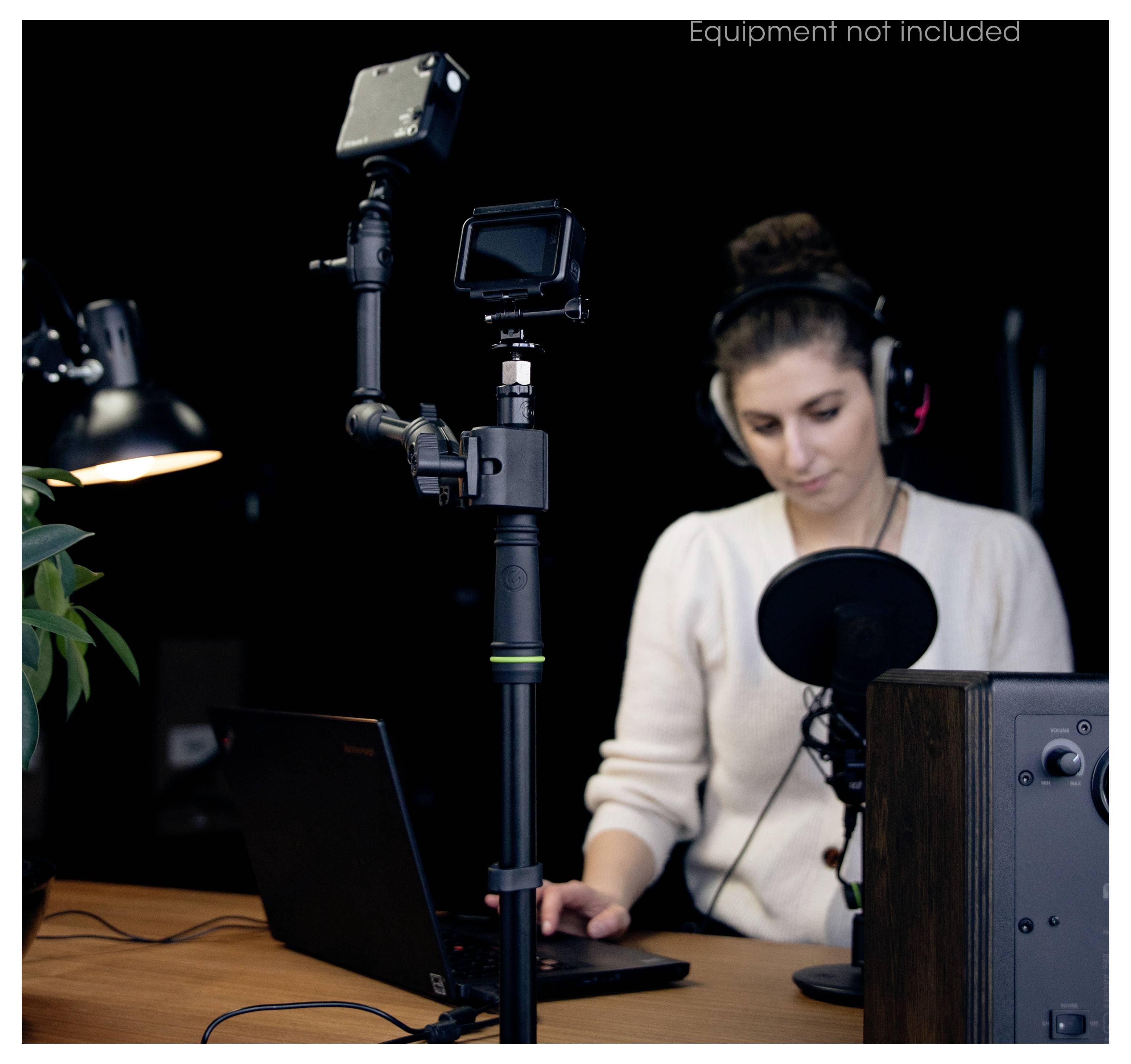 Žena koja snima zvuk ili video na stolu s laptopom, mikrofonom i kamerom na stativu u studijskom postavu.