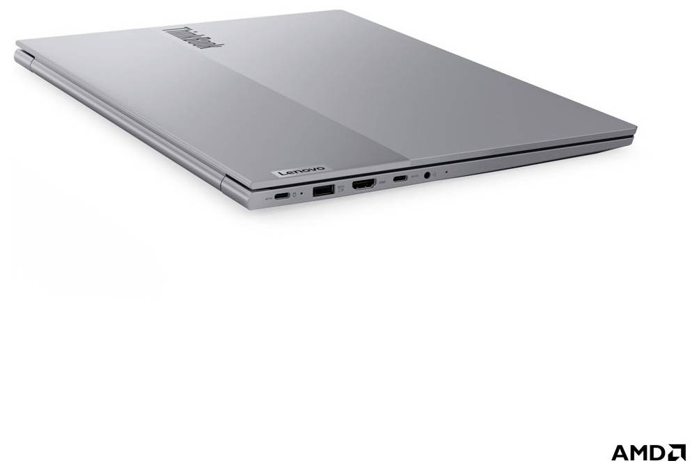 Zatvoreni srebrni laptop prikazan pod kutom na bijeloj pozadini, sa vidljivim bočnim priključcima i AMD markiranjem.