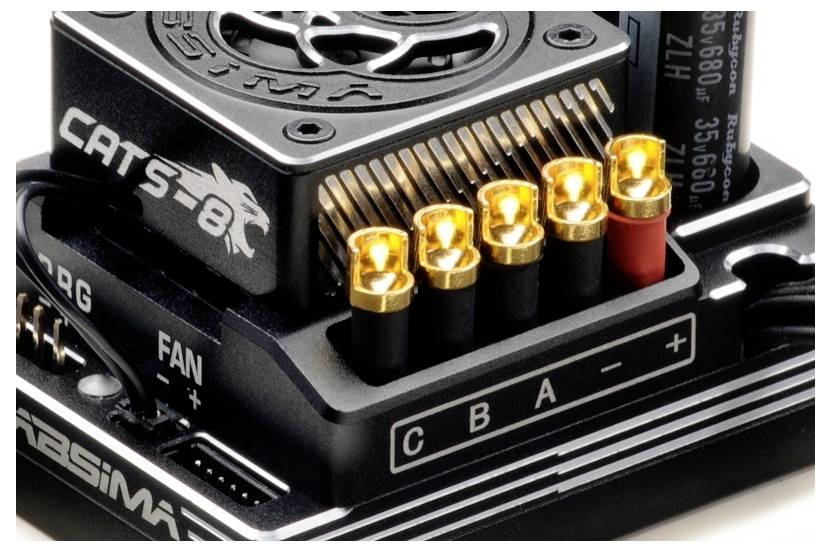 Detaljni prikaz elektronskog uređaja CAT'S-B8 s pet osvijetljenih zlatnih priključnih pinova označenih s C, B, A, -, i +.