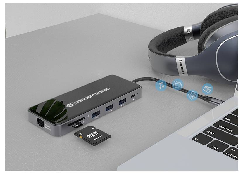 USB-C hub sa SD karticom i USB flash pogonodm priključenim pokraj laptopa i slušalica na stolu.