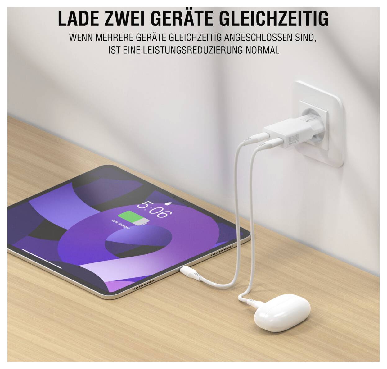 Tablet se puni iz zidne utičnice s dva povezana uređaja; njemački tekst kaže da puniranje više uređaja istovremeno može smanjiti snagu, što je normalno.