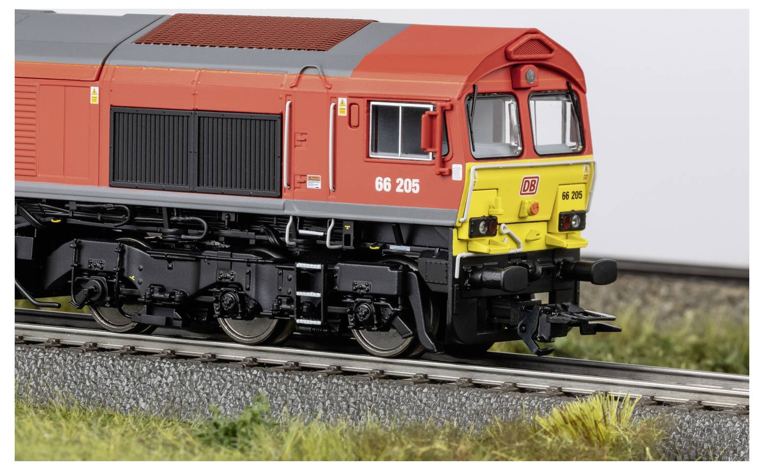 Detaljan snimak crvenog i žutog modela dizelske lokomotive na tračnicama, prikazan s prednje strane s vidljivim brojem 66 205.
