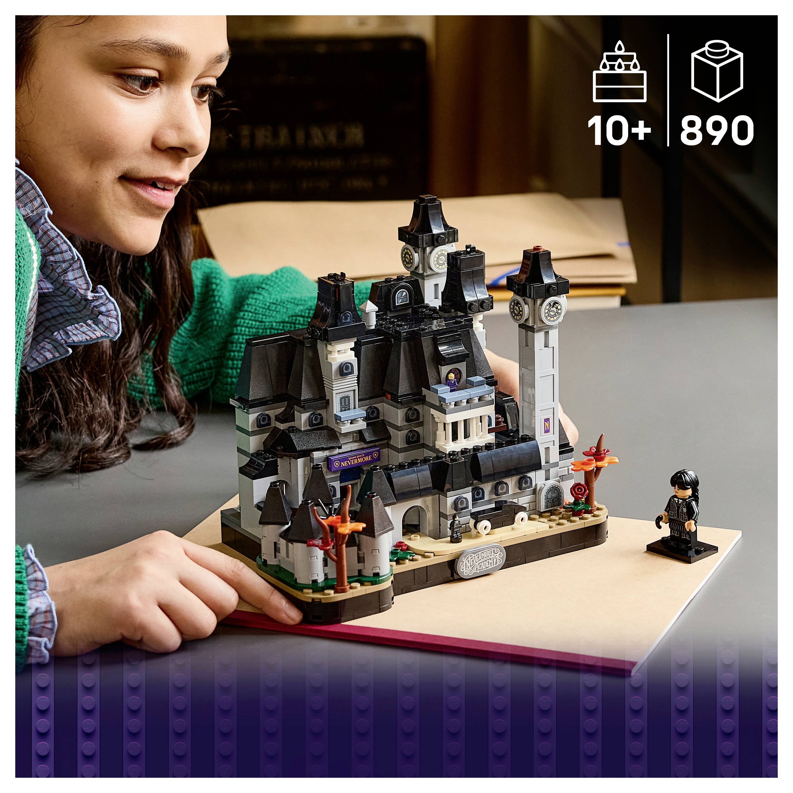 Dijete koje se igra sa LEGO-sličnom postavkom malog zamka od komada s malenom minifigurom pored njega; dobna granica 10+ i prikazano 890 komada.