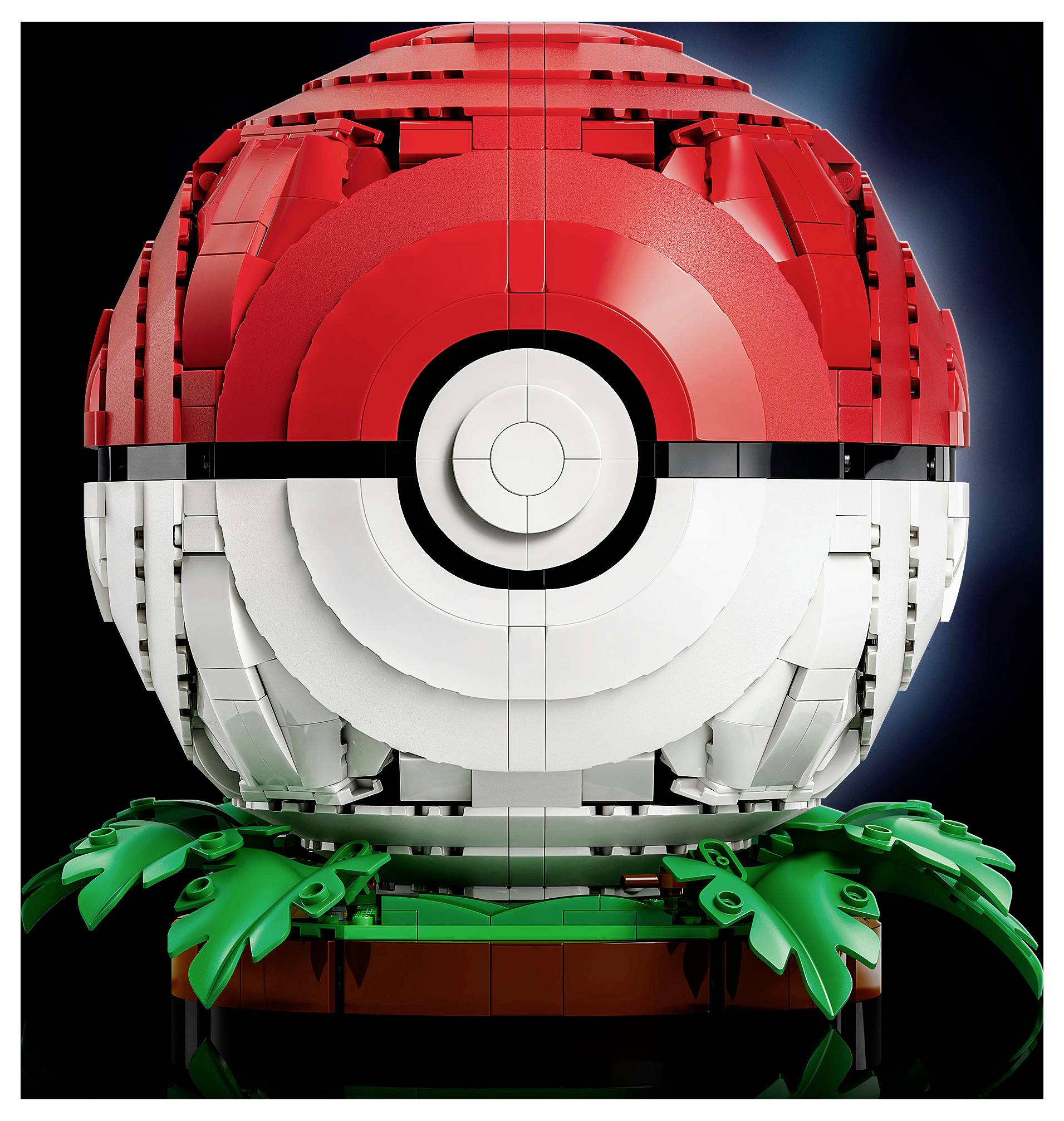 LEGO-sličnom Poké Ballu napravljen od crvenih, bijelih i crnih kockica, koji počiva na zelenim komadima lišća nasuprot tamnoj pozadini.
