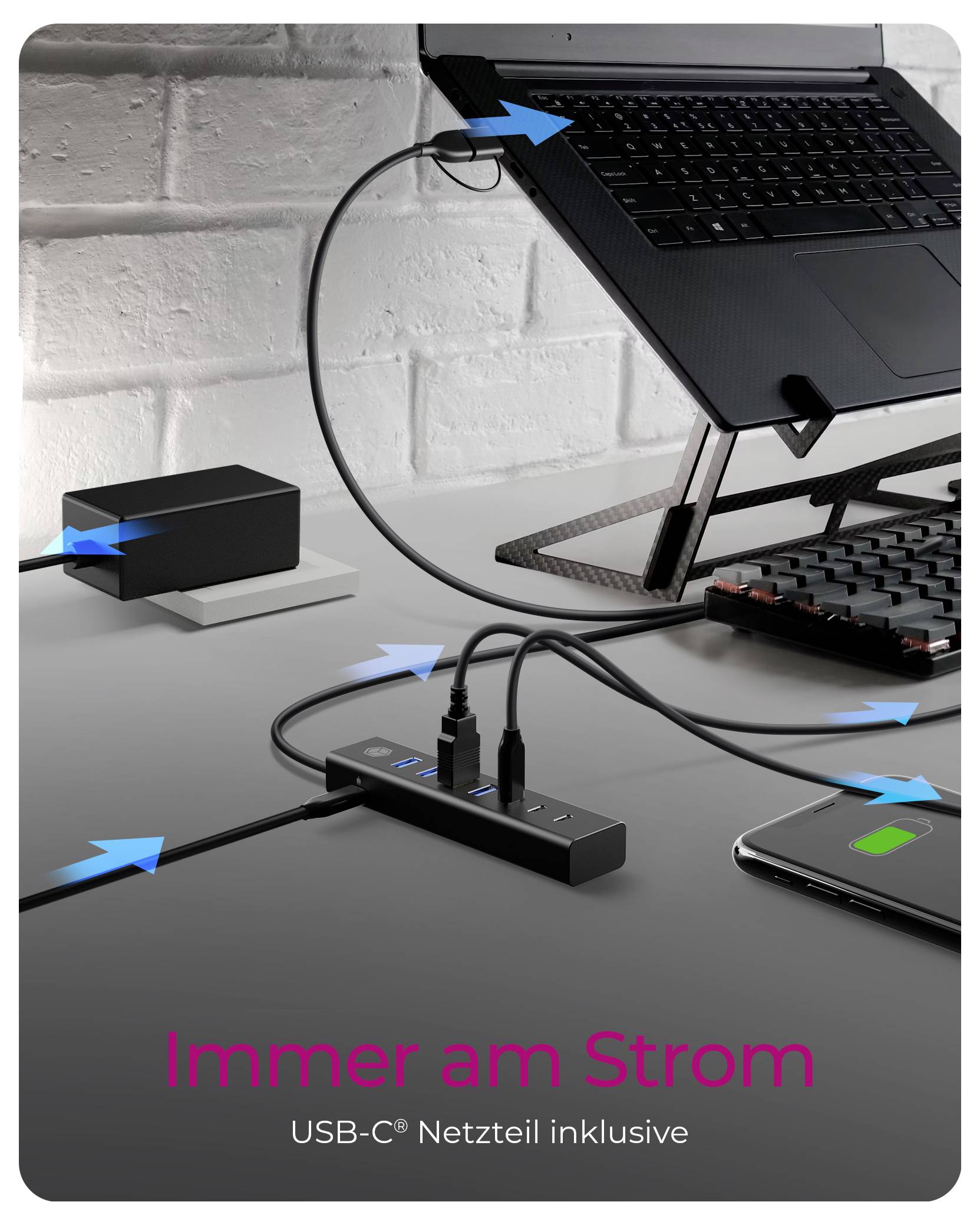 Promocijska slika laptopa prislonjena na stalak s USB-C hubom za napajanje, kablima za punjenje i telefonom; tekst glasi "Uvijek na struji" i "USB-C napajalni adaptor uključen".