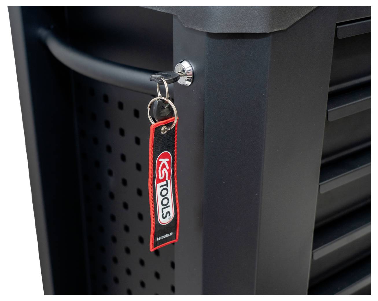 Blizak bravu s crvenom etiketom ključa 'K-TOOLS' koja visi sa crnog metalnog ormara ili sanduka za alat.