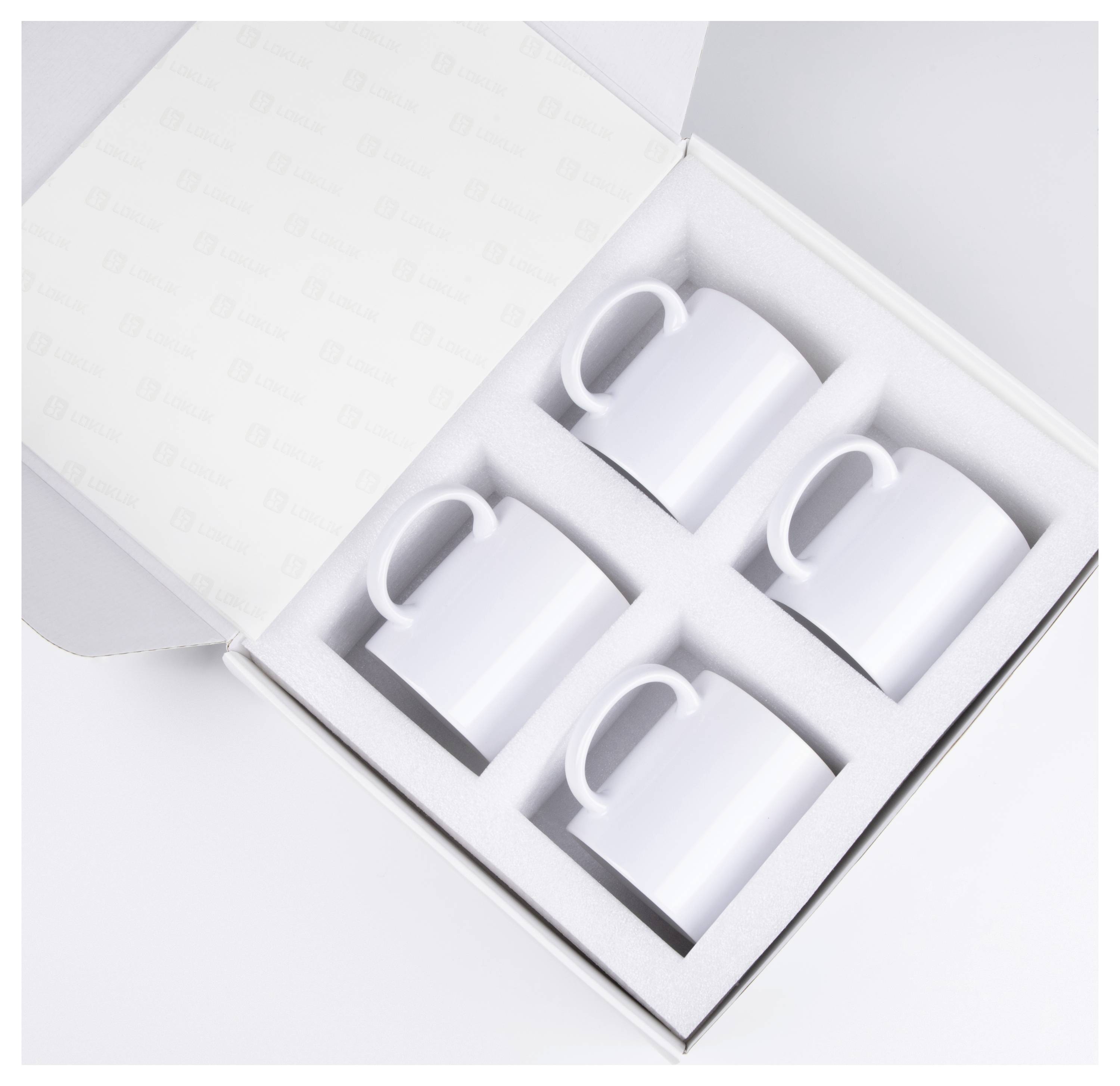 Četiri bijele keramičke šalice u kutiji za prezentaciju sa zakovičanim poklopcem, raspoređene u mreži od 2 na 2 na bijeloj pozadini.