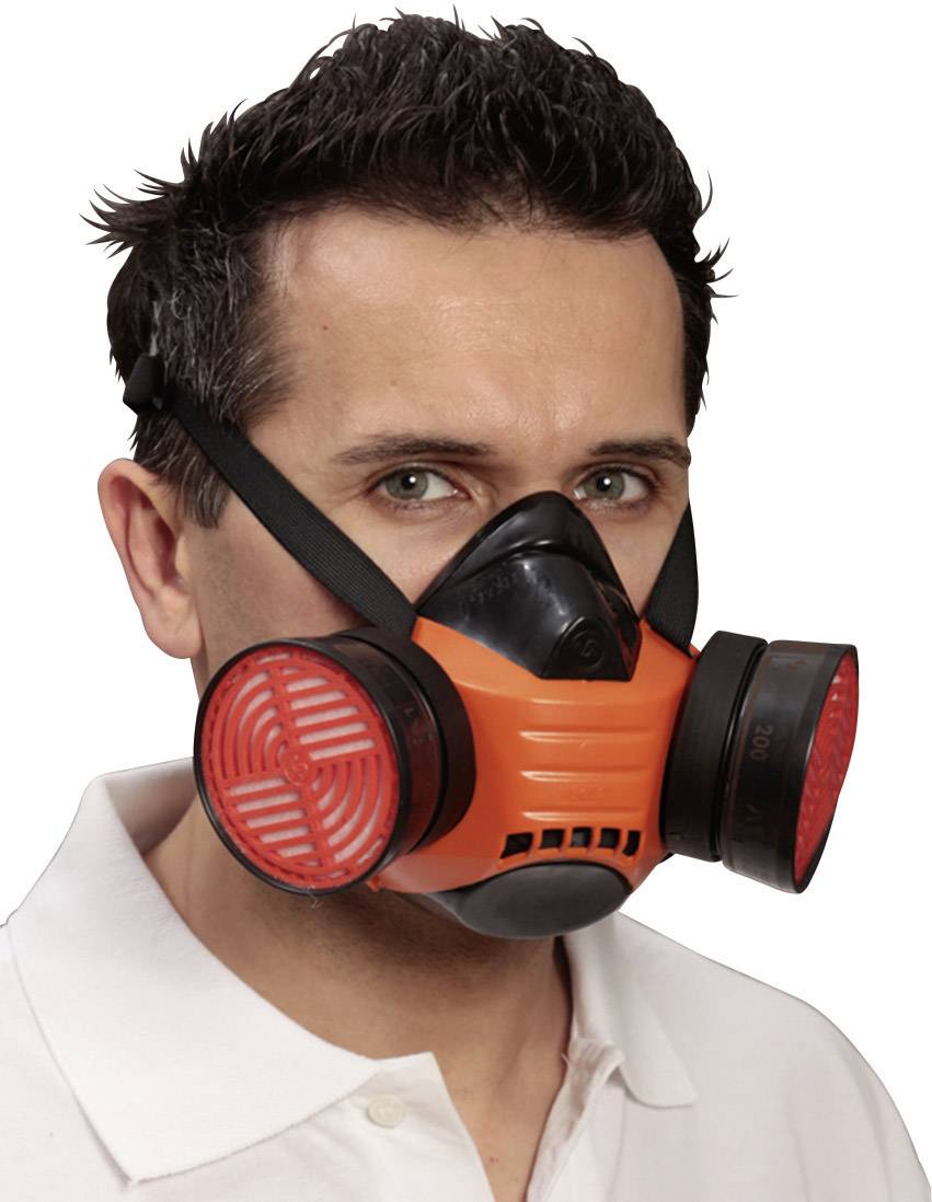 Muškarac nosi narančasto-crnu zaštitnu masku za disanje s okruglim filterima na obje strane. Ima tamnu, kratku kosu.