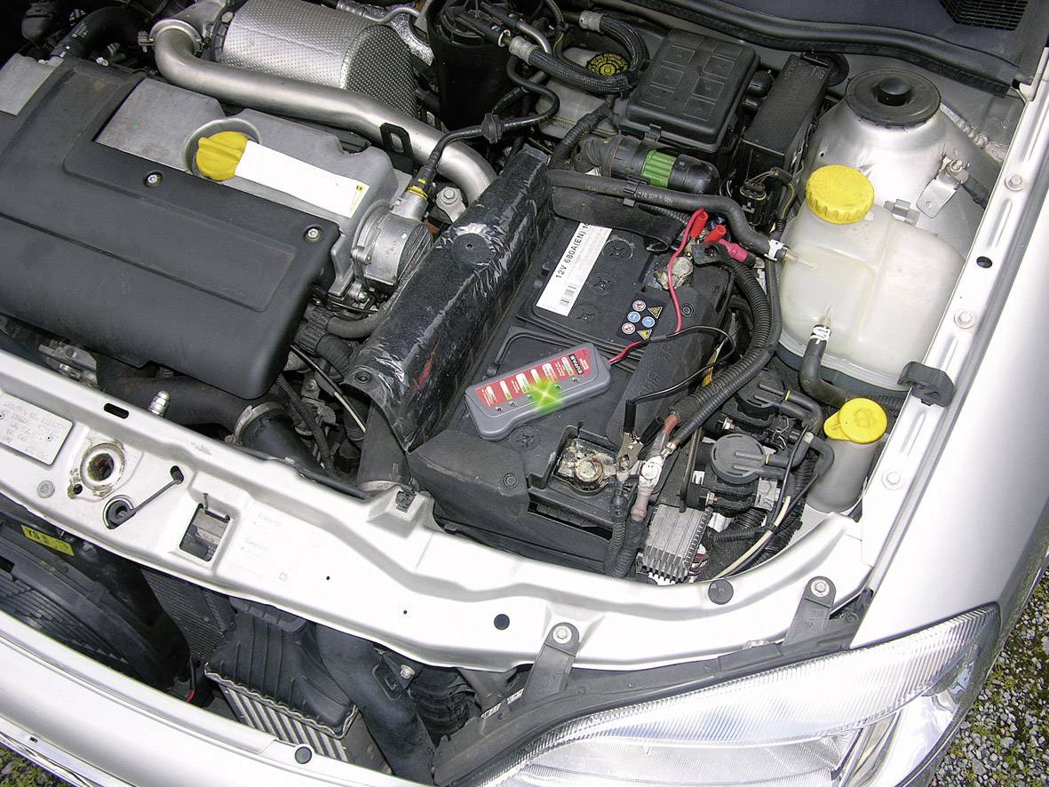Motorni prostor automobila s vidljivom baterijom, hladnjakom i motorom. Različiti dijelovi označeni su žutim poklopcima.