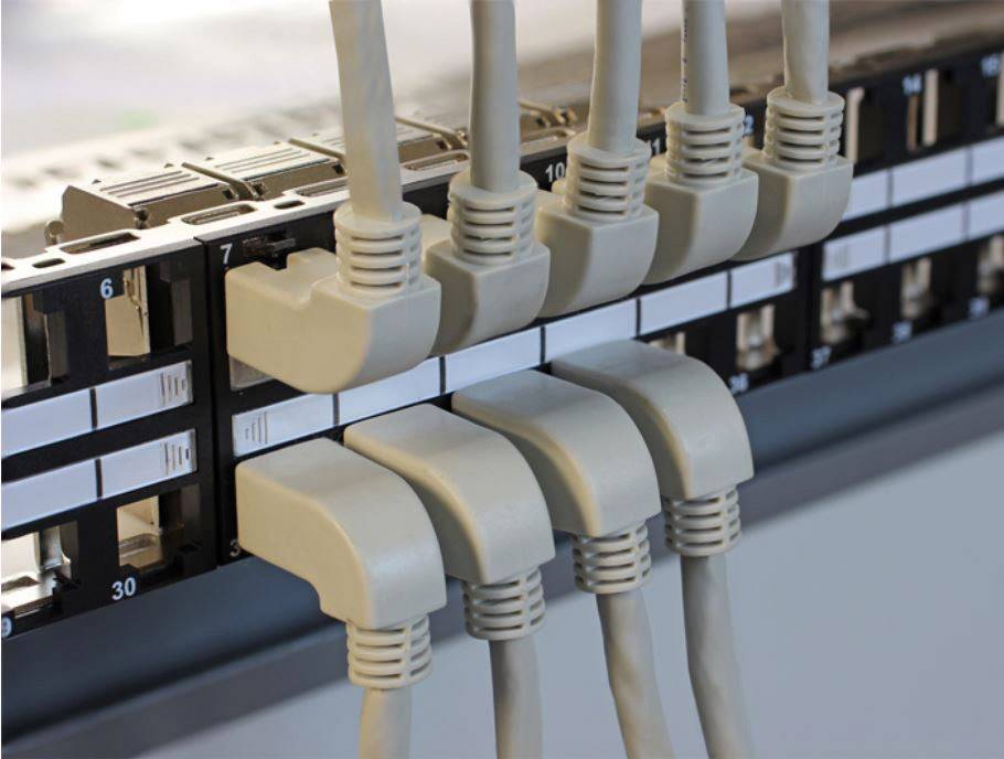 Mrežni patch panel s više uključenih Ethernet kabela prikazuje organizirano upravljanje kabelima u podatkovnom centru.