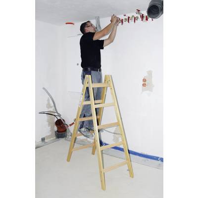 Jedna osoba stoji na ljestvama i instalira električne kablove na stropu prostorije. U pozadini su vidljivi alati.