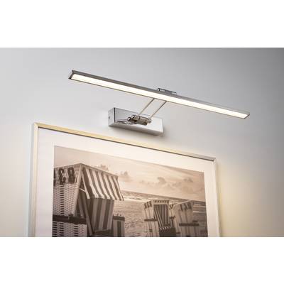 Stilska zidna lampa osvjetljava fotografiju koja prikazuje plažne ležaljke pokraj mora. Lampa je moderna i usmjerava svjetlo precizno na sliku.
