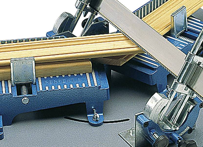 Plava potezna pila upravo reže snop drvenih letvica. List pile je blago nagnjen, a stroj djeluje industrijskim izgledom.