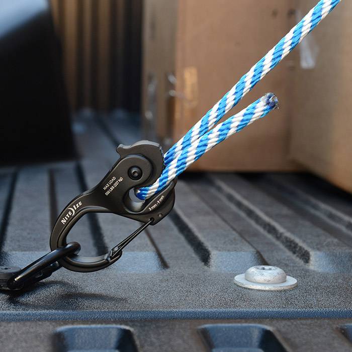 Plavo-bijelo uže pričvršćeno je za crni karabiner koji je postavljen na teretni prostor vozila.