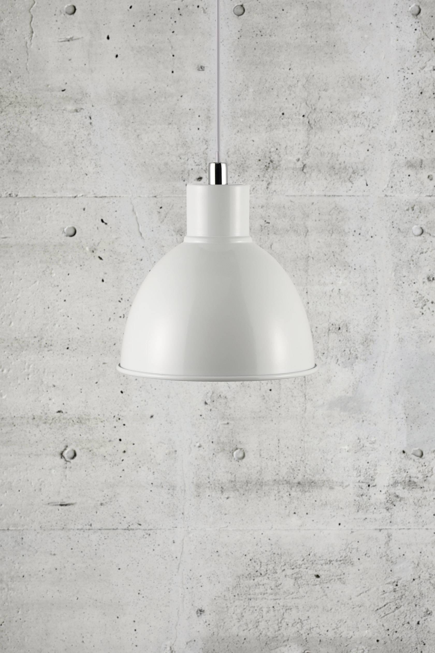 Bijela viseća lampa jednostavnog, modernog dizajna visi ispred sive betonske stijene.