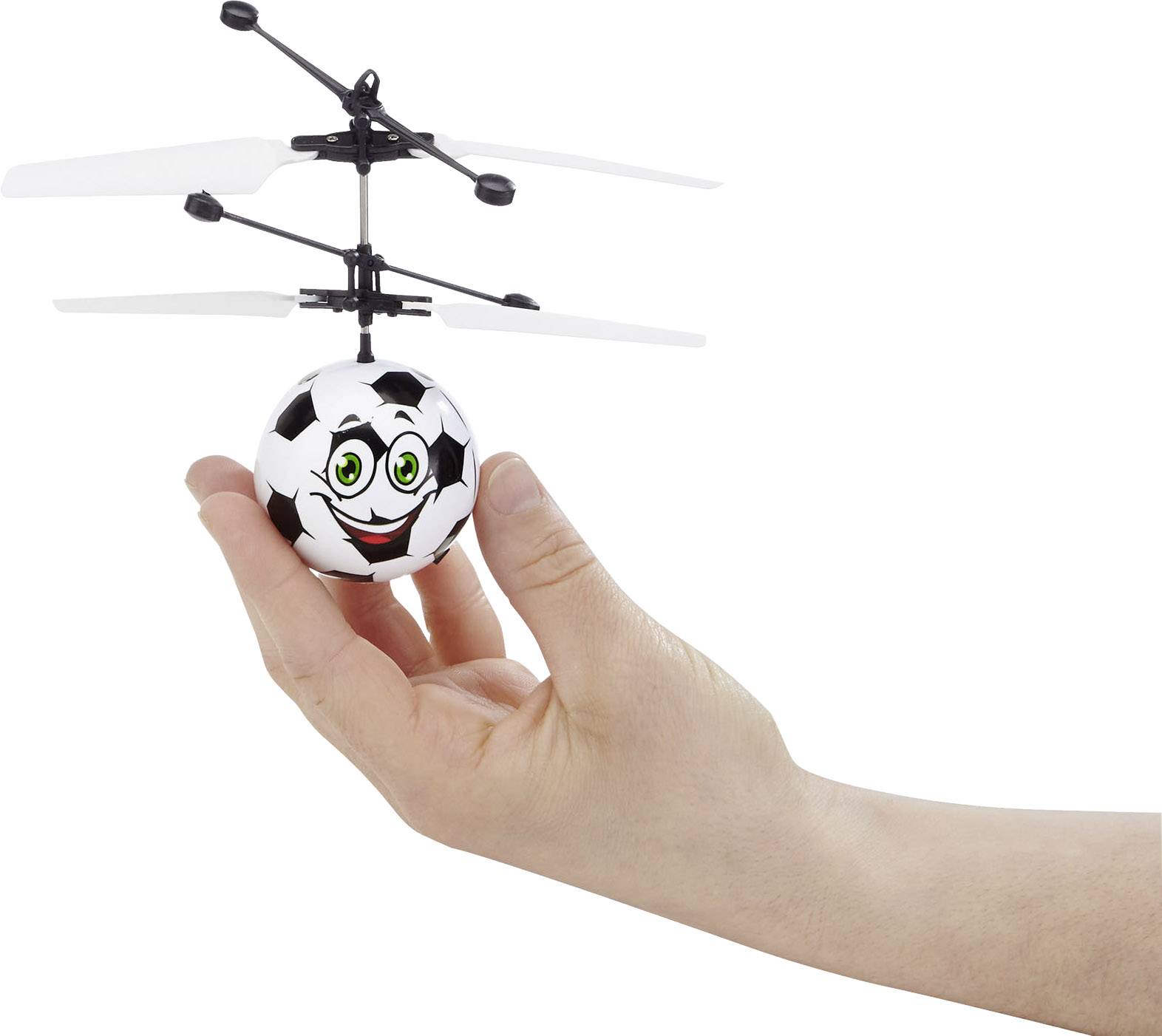 Jedna ruka drži lebdeći mini-helikopter s licejem nogometaša koji se smije.