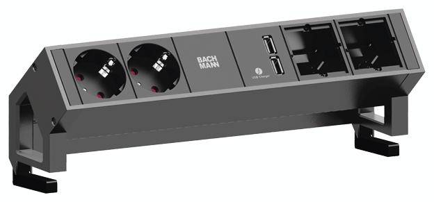 Crno stolno priključno polje marke Bachmann s dvije Schuko utičnice, dva USB priključka i dva prazna ugradbena otvora.