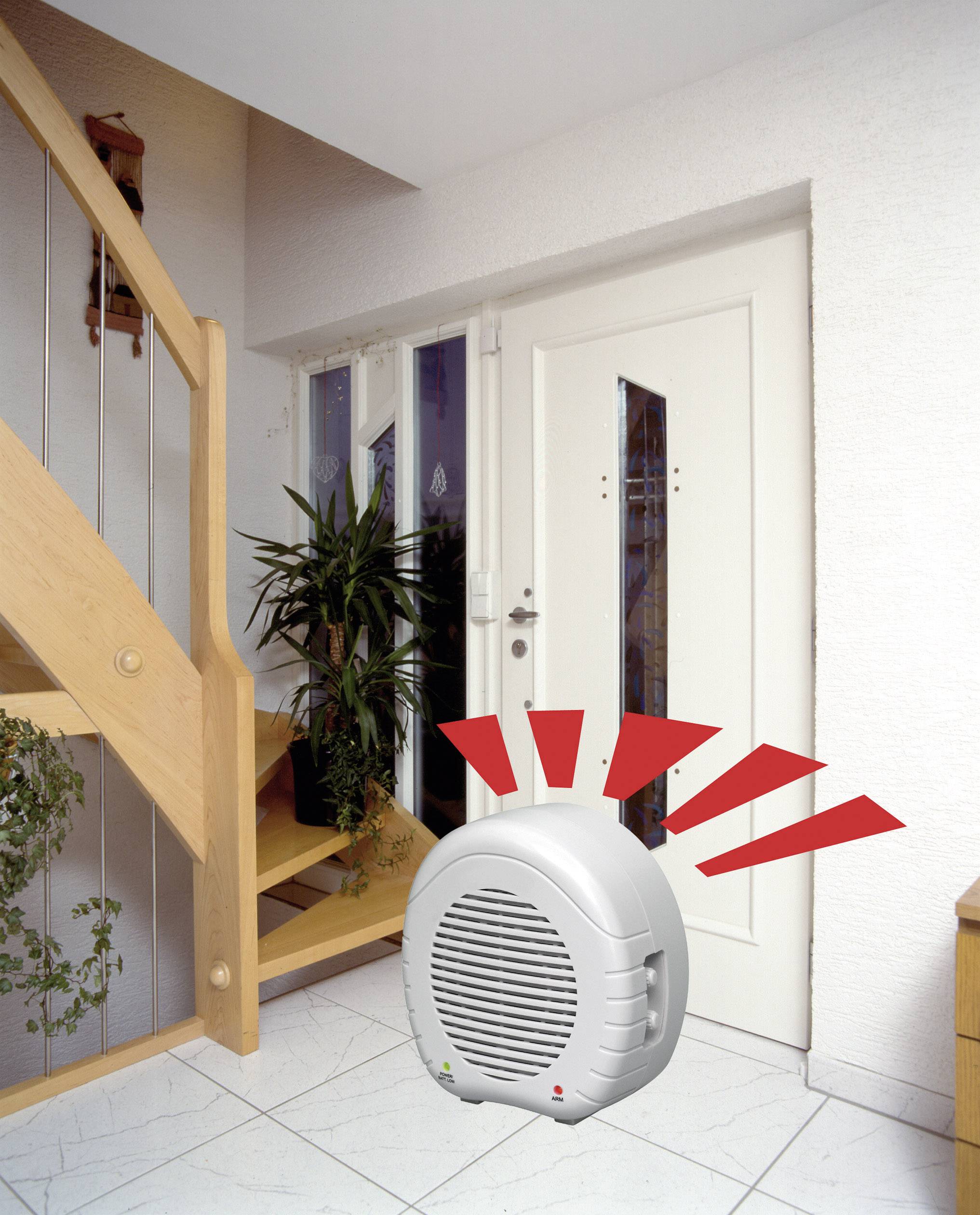 Električni ventilator stoji na bijeloj pločastoj podlozi blizu ulaznih vrata. Crvene linije simboliziraju strujanje zraka.